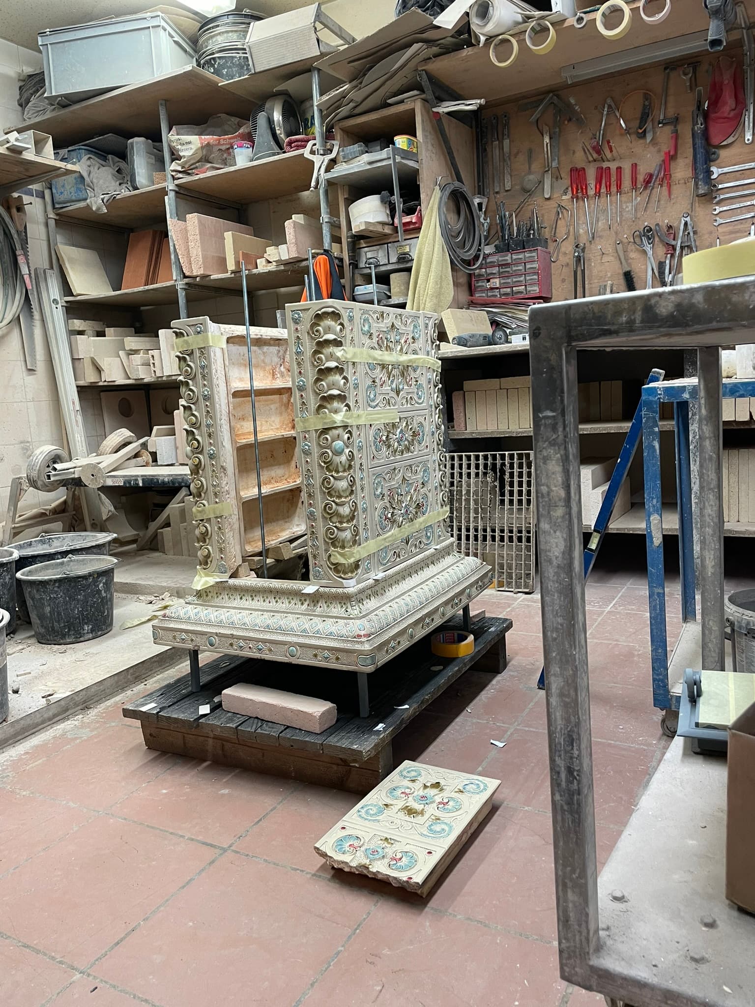 Historischer blauer Ofen und einzelne Kacheln in der Werkstatt