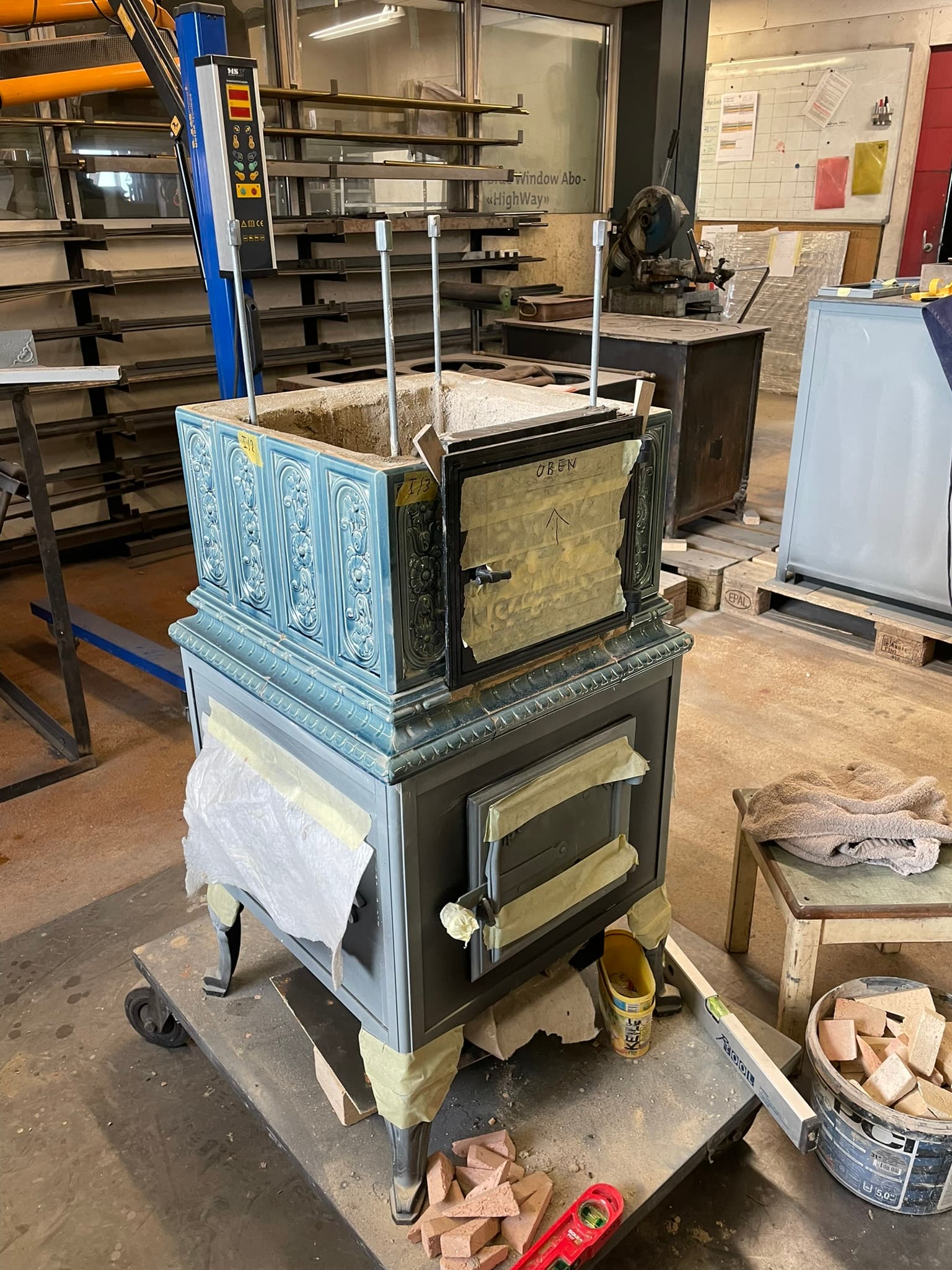 Teilweise aufgebauter blauer historischer Ofen in der Werkstatt
